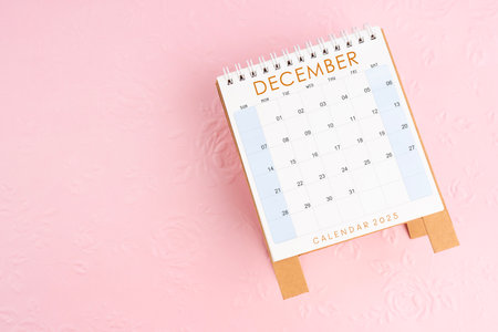 December 2025 desk calendar on pink paper with flower pattern background, Flat lay.の写真素材