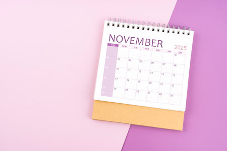 November 2025 desk calendar on pink and purple color background.の写真素材