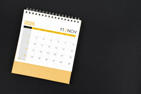 Top view of November 2025 desk calendar on black color leather background.の写真素材