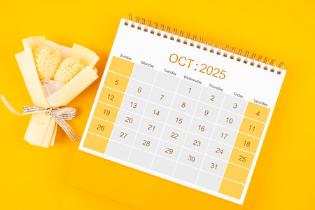October 2025 desk calendar with bouquet flower on yellow color background.の写真素材