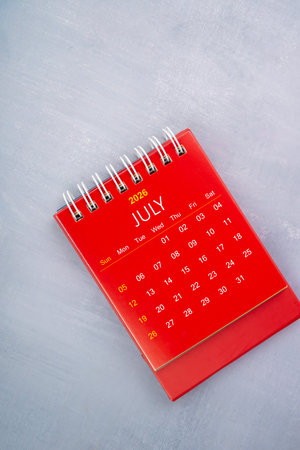 July 2026 red color calendar on wooden blue background.の写真素材