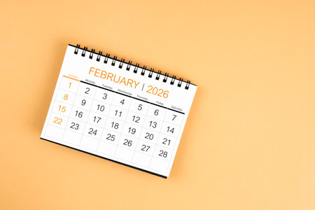 Top view of February 2026 desk calendar on yellow pastel color background.の写真素材