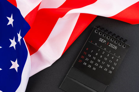 September 2026 black color monthly desk calendar and United States of America flag.