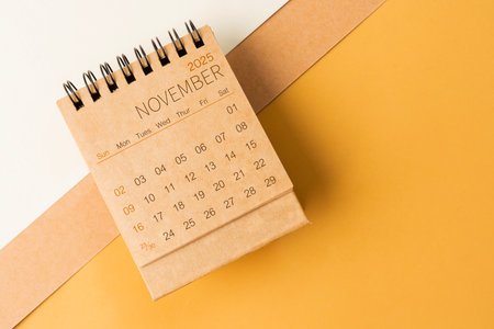 Blank desk calendar for November 2025 on brown tone color background.の写真素材
