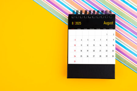 Desk calendar for August 2025 year on yellow color background, Position with copy space.の写真素材