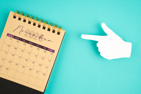 November 2026 calendar from craft paper with paper note finger shape on blue background.の写真素材