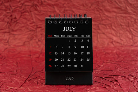 July 2026, Front view black desk calendar on crumpled red paper background.の写真素材