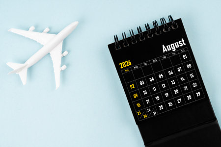 August 2026 black calendar and airplane toy on blue background.の写真素材