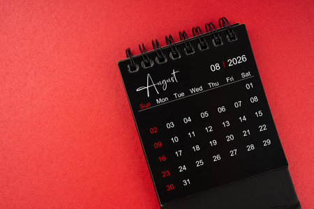 August black desk calendar for 2026 year on red cover background.