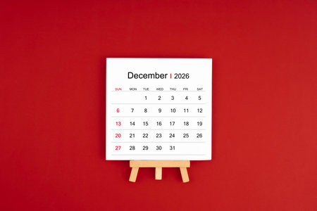 Calendar page for December 2026 with wood easel on a red background.の写真素材