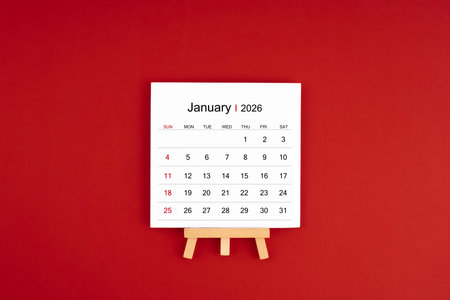 Calendar page for January 2026 with wood easel on a red background.の写真素材