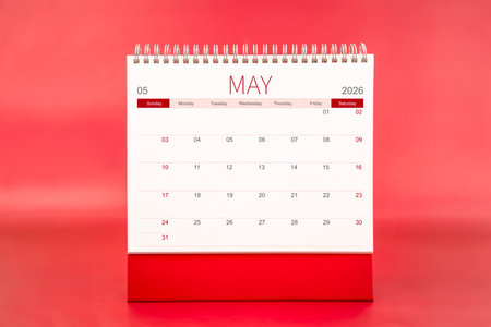 May 2026 blank desk calendar on red background.の写真素材