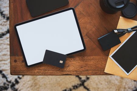 Digital tablet with debit card and smart phone on table with photography equipment.の写真素材