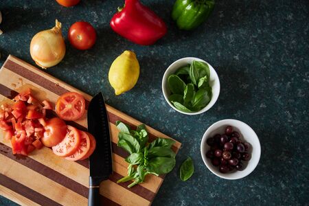 Flat-lay of ingredients being prepared for dinner on wooden chopping board.の写真素材