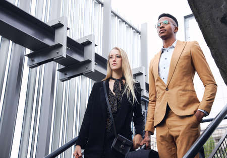 Business Couple On Trip With Luggage Outside Office Buildingの写真素材