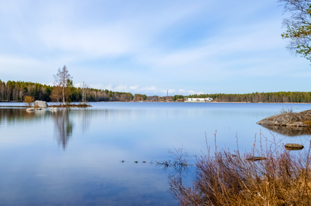 long exposure photograph of clean water lake surrounded by pine birch trees and scenic beauty under...