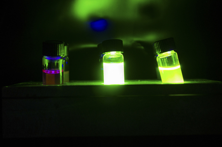 Colourful light induced catalyst photochemical reaction in glass vials under green light in a dark...