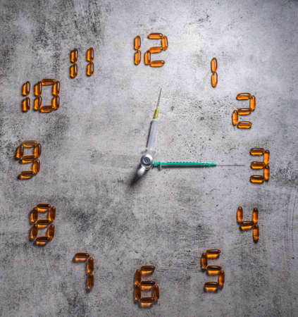 Transparent yellow with health clock by syringe and vial of liquid drug. connection between Medicinal chemistry and drug development. copy space.の写真素材