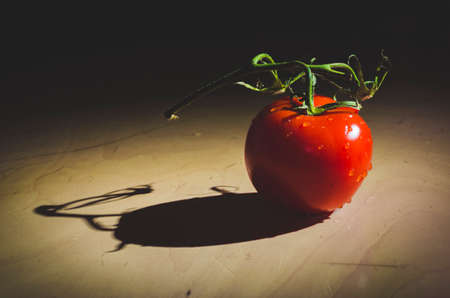 Healthy fresh tomato on  table under the light as backgroundの写真素材