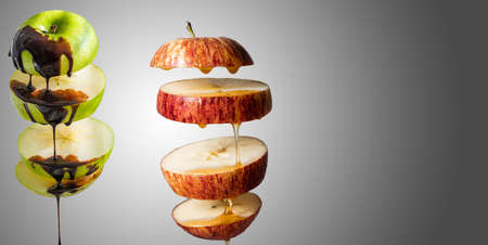 Fresh sliced green apple and melted chocolate dripping in flying food with levitation reflection. Alternative sugar substitute and body strengthening, superfood breakfast yellow background. copy spaceの写真素材
