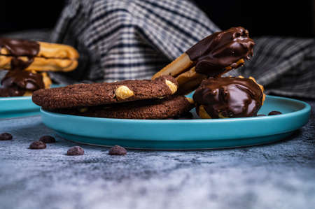 Dark chocolate coated digestive biscuit with chocolate cookies for loved ones valentines day celebration. Partially eaten with crumbs. side view.の写真素材