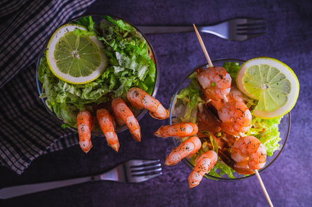 Close up view of Prawn cocktail starter served in a tropical tourist restaurant in a glass with decoration of prawn with sprinkle of dill, lemon, lettuce and alcohol mixの写真素材