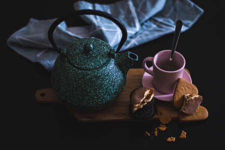 Valentines day healthy breakfast for couple with ceramic green teapot, chocolate cookies and heart shaped biscuit with a vintage look backeryの写真素材