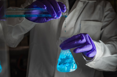 A woman scientist performing Organic reaction under fuming condition in a laboratory. Fume,...