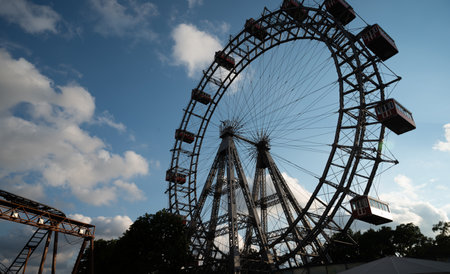 Giant Ferris wheel moving with people in an Amusement park. Bright sunny day for entertainment. Copyspace.の写真素材