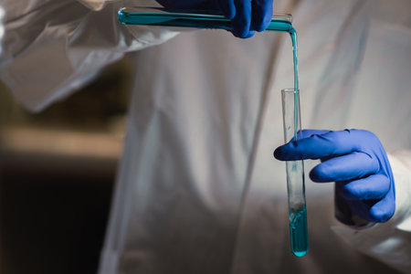 A scientist conducting experiments in a laboratory setting, using a pipette to transfer blue-green...