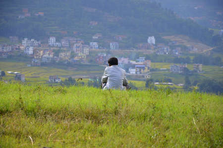 A man sitting alone and enjoying the beauty of natureの写真素材