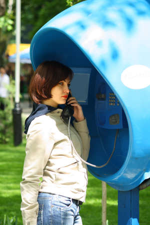 The girl pending the answer in the middle of spring blossoming parkの写真素材