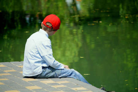 The child near lake, sits in the warm spring afternoonの写真素材