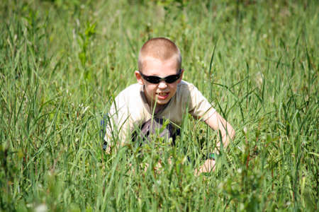 The boy in a grass on the nature plays security serviceの写真素材