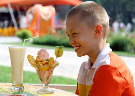 The boy in city cafe with a dessertの写真素材
