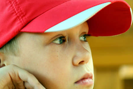 Boy watches in a cap with interest on representationの写真素材