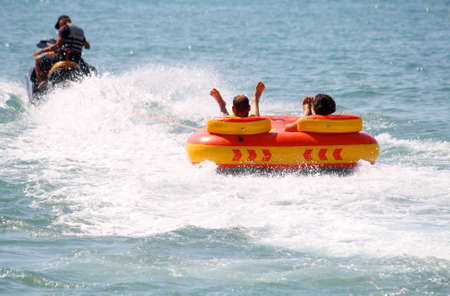 Walk on an inflatable mattress at ocean on a tow of a water motorcycleの写真素材