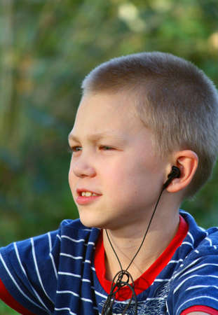 Teenager listens to music in headphones with a playerの写真素材