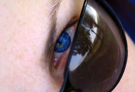 Blue eye looks atop of glassesの写真素材