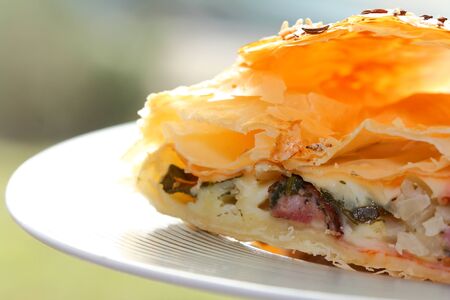 roll from puff pastry filled with meat and vegetables on plate
