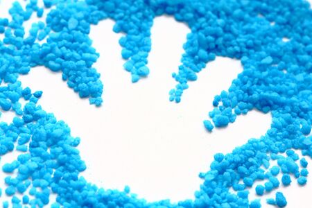 close up of print child hand on blue salt