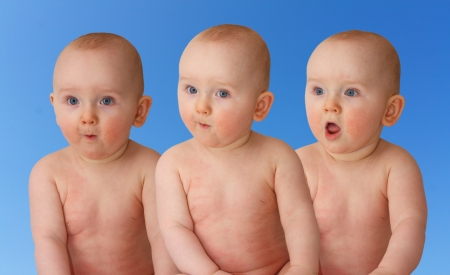triplets with astonishment looks over white backgroundの写真素材