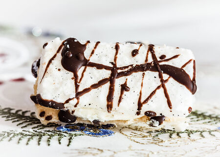close up of Christmas sweets with chocolate and cream on table cloth