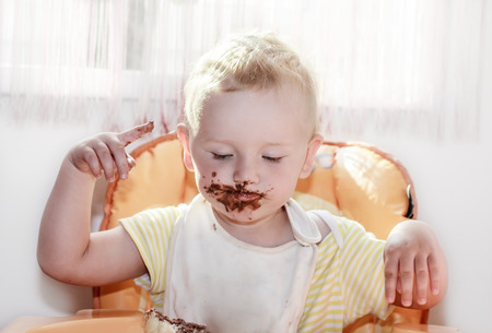 chocolate on face, funny cute eating boy, messy eaterの写真素材