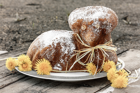 Czech Easter - baked lamb with powdered sugar and dandelions on old wood desk