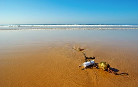 a message bottle run ashore and stuck on an anchor rope with a buoy