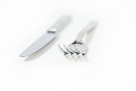 A knife and a fork isolated on a white background with a shallow depth of fieldの写真素材