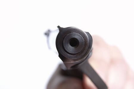 The pistol directed on you, on a white background, shallow DOF
