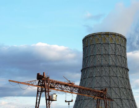 The bridge crane and cooling tower against the skyの写真素材