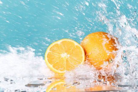 fresh orange with water splash on green background